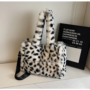 Close-up of black and white leopard print plush tote bag with a wide black shoulder strap