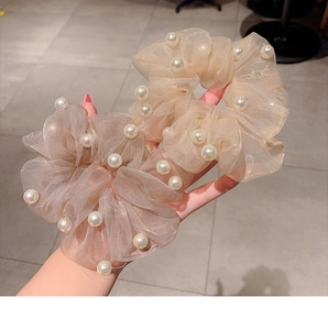 Detailed view of handmade organza hair scrunchies with elegant pearls in beige and pink