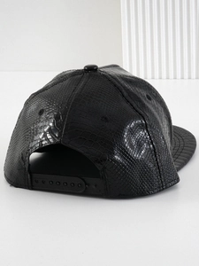 Detail of adjustable snapback closure on black textured faux leather baseball cap