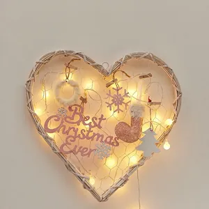 Handmade wicker heart Christmas wreath with LED lights and pink festive ornaments