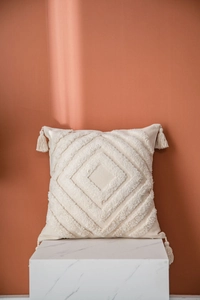 Close-up of tufted Moroccan pillow cover with diamond pattern and corner tassels