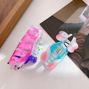 Pink marble and blue butterfly acrylic hair claws set on a magazine background
