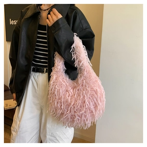 Detail of pink faux fur tassel handbag with plush fringe texture on a fashion model