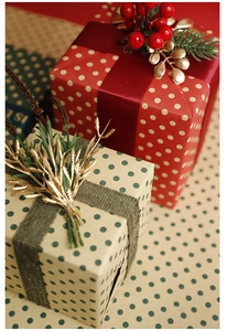 Detailed view of red and kraft paper gift boxes with festive ribbons and pine accents