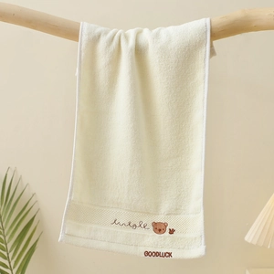 Detailed embroidery of a bear and Goodluck text on soft cream cotton children towel