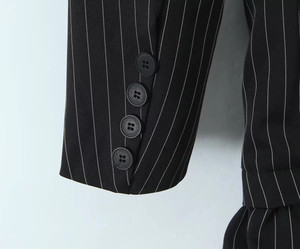 Détail du poignet d'un blazer rayé avec quatre boutons noirs et coutures précises