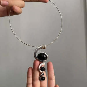 Detailed view of silver spiral choker featuring three inlaid black oval resin gemstones