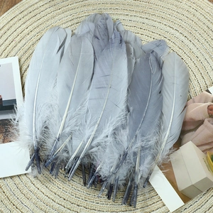 Macro shot of gradient grey goose feathers on woven mat for DIY handicraft decor