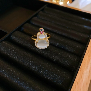 Macro detail of gold plated gourd ring with cat-eye stone and zircon on black velvet