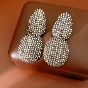 Dettaglio macro di orecchini vintage a goccia con strass scintillanti incastonati