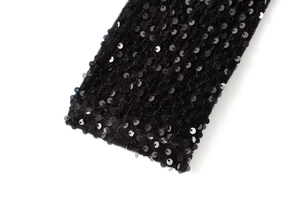 Vue macro du tissu à paillettes noires montrant la texture brillante sur base de velours