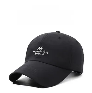 Close-up of white embroidered text on breathable black quick-dry outdoor baseball cap