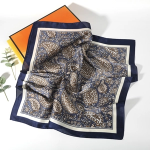 Detail shot of navy blue paisley silk scarf with elegant gift box packaging