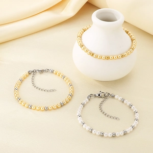Elegant beaded bracelet set with pearls and gold metal beads on a silk fabric background