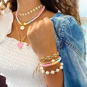 Detail of layered Bohemian jewelry with polymer clay beads and heart pendant