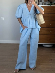 Detail of light blue linen set with V-neck puff sleeve top and wide-leg trousers