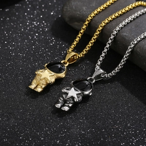 Macro view of gold and silver astronaut pendants with stars on dark starry background