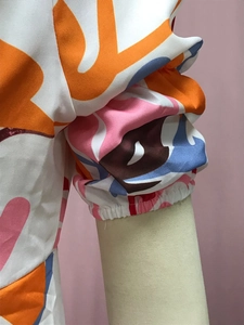 Close-up of elastic lantern sleeve cuffs and abstract geometric print on floral dress