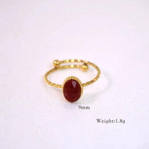 Detail of vintage gold-plated twist ring with 9mm faceted red natural stone