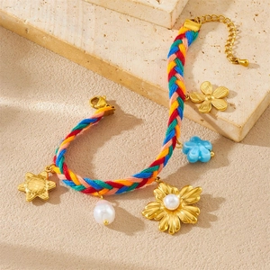 Detail of colorful woven bracelet with gold sunflowers, resin flowers and pearls