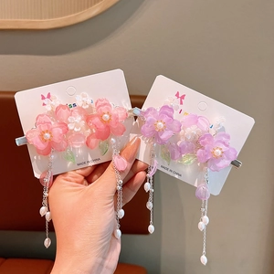 Detail of pink and purple cherry blossom hair clips with pearls and long tassels