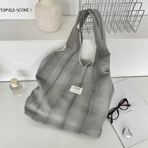 Detail of stone-washed grey tie-dye canvas tote bag with a minimalist woven label