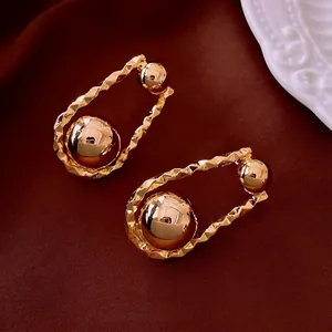 Modern gold-plated earrings featuring irregular hammered texture and smooth double metal spheres