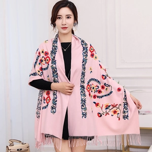 Detail of pink embroidered scarf featuring colorful floral patterns and decorative tassels