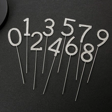 Macro detail of sparkling silver glitter number cake toppers with long metal sticks