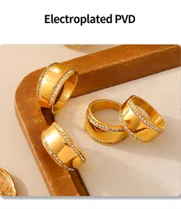 Detail of PVD gold plated wide bands featuring sparkling side stones on a display tray