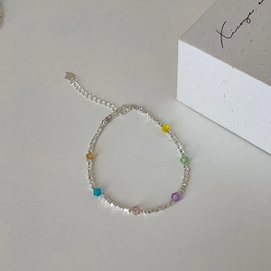 Detail of silver chain bracelet with colorful crystal beads and heart pendant on white background