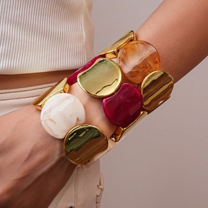 Dettaglio di un ampio bracciale elastico in acrilico con inserti in marmo e resina ambra