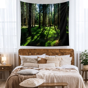Bohemian forest wall tapestry hanging in a cozy bedroom with natural woodland sunlight