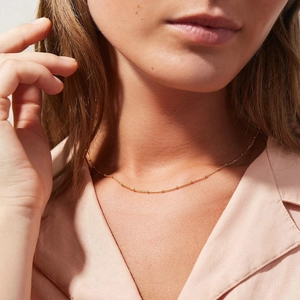 Elegant gold bead chain necklace for women shown on a model neck in a minimalist style