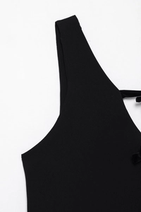 Détail de la maille côtelée et du nœud en velours noir sur la bretelle de robe