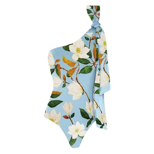 Detail of one-shoulder light blue floral swimsuit with white magnolia print and shoulder tie
