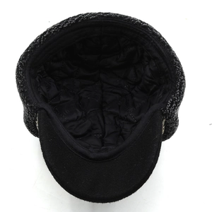 Detail of tweed newsboy cap showing warm quilted inner lining and textured fabric