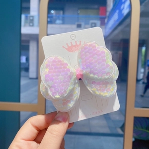 Detailed view of pink sequin bow hair clips on a white branding card for girls