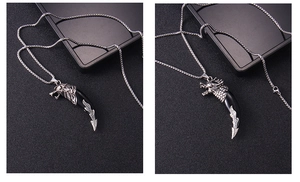 Macro detail of a silver wolf head pendant with a black claw and flame pattern design