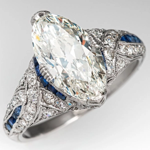 Vintage marquise cut diamond ring with blue sapphire accents and floral engraving