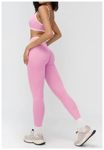 Detail showing pink yoga bra and high-waist leggings with white piping accents
