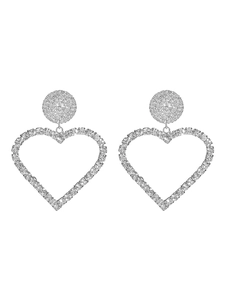 Detailed close-up of heart-shaped silver earrings with shimmering rhinestone paving