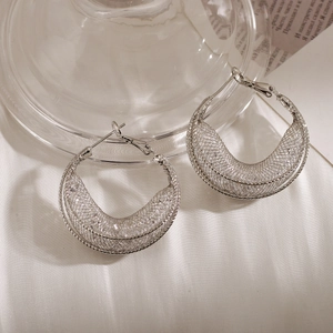 Retro luxury silver hollow mesh circle earrings with artistic weaving on white silk