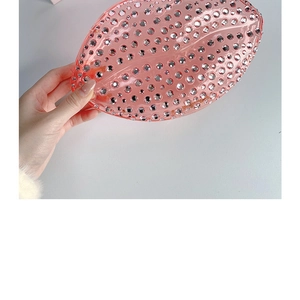 Close-up of pink lip-shaped evening clutch bag with sparkling rhinestone embellishments