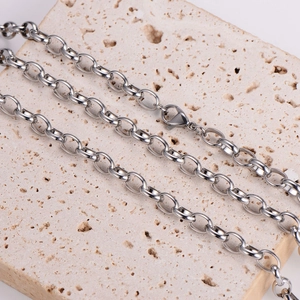 Polished silver metal oval link chain necklace displayed on a natural stone background