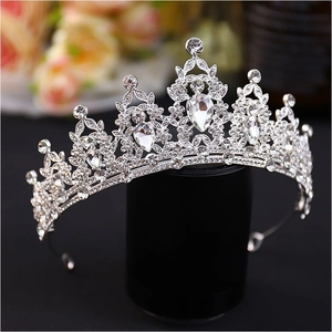 Close-up of sparkling silver crown with pear-cut rhinestones on black display stand