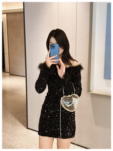 Close-up of black sequined off-shoulder dress with elegant feather collar detailing
