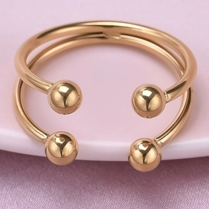 Gros plan d'une bague double en or rose avec perles sur une assiette en céramique