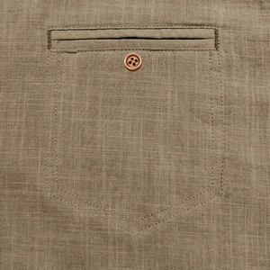 Close-up of khaki linen beach shirt pocket with wooden button and stitched details
