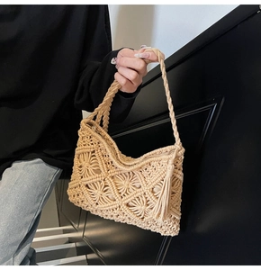 Détail d'un sac à bandoulière tissé beige avec motifs floraux creux et longues franges